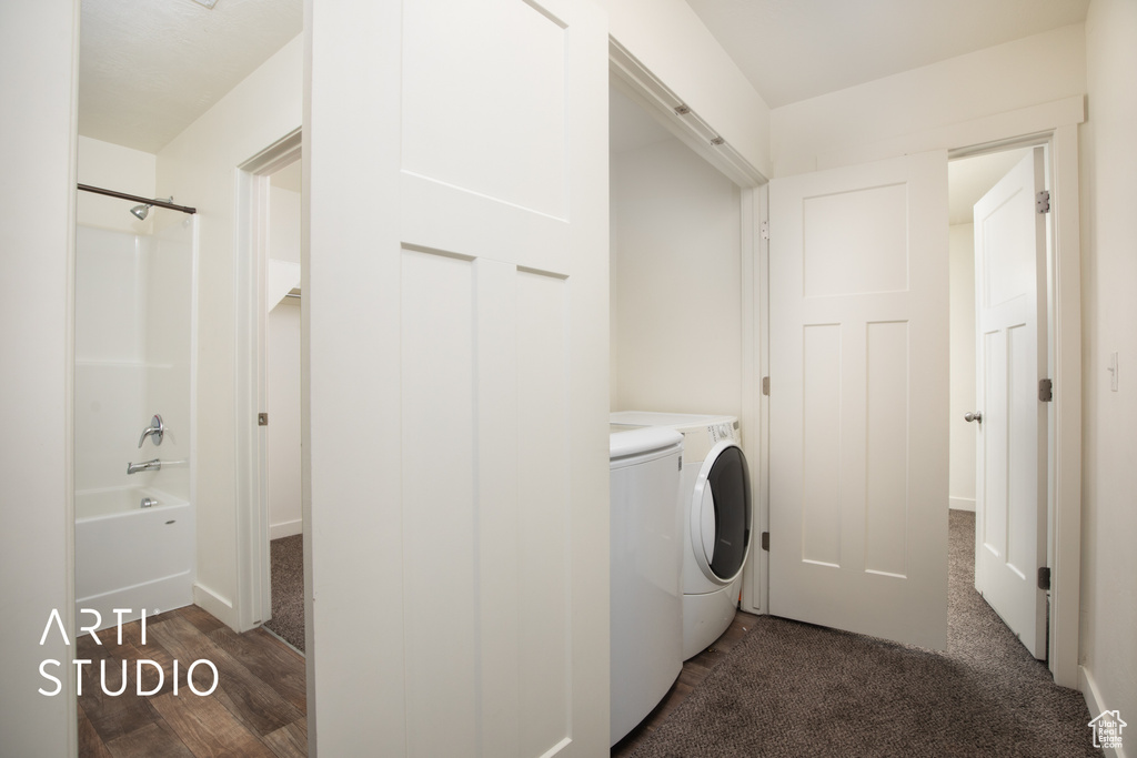 Laundry area with washer and dryer and dark wood-style flooring