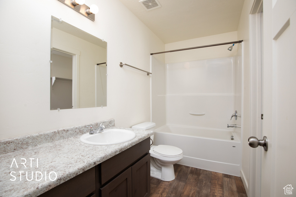 Bathroom with vanity, wood finished floors, and tub / shower combination