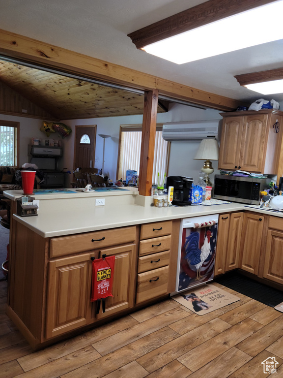 Kitchen featuring stainless steel microwave, light wood-style flooring, light countertops, and open floor plan