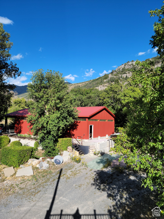 View of side of home featuring an outbuilding and a mountain view