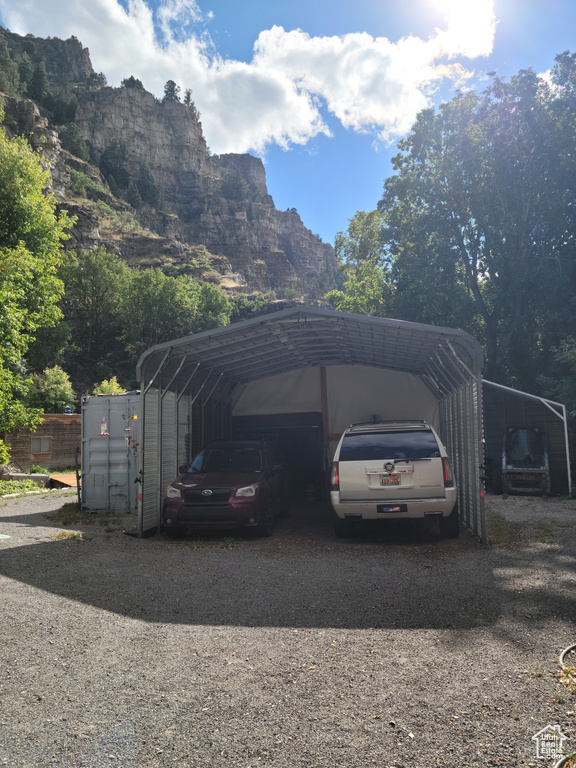 View of car parking featuring a carport, driveway, and a mountain view