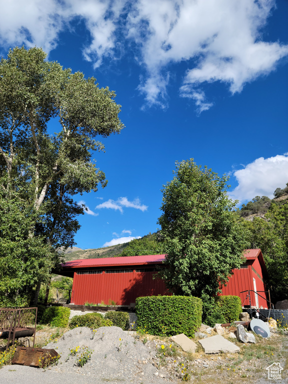 View of property exterior featuring an outdoor structure and a pole building