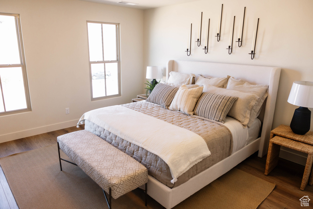 Bedroom featuring wood finished floors and multiple windows