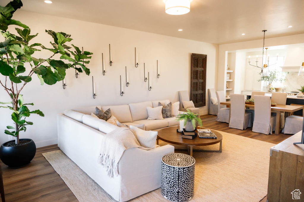 Living room with wood finished floors, recessed lighting, and a chandelier