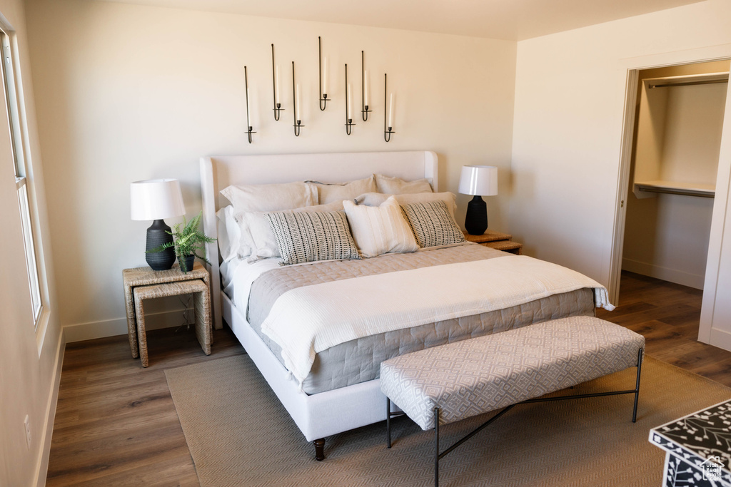Bedroom featuring dark wood-style floors and baseboards