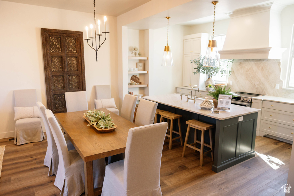 Dining room with wood finished floors and a chandelier