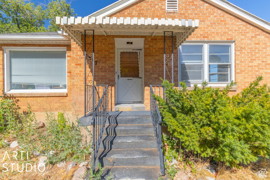View of exterior entry with brick siding