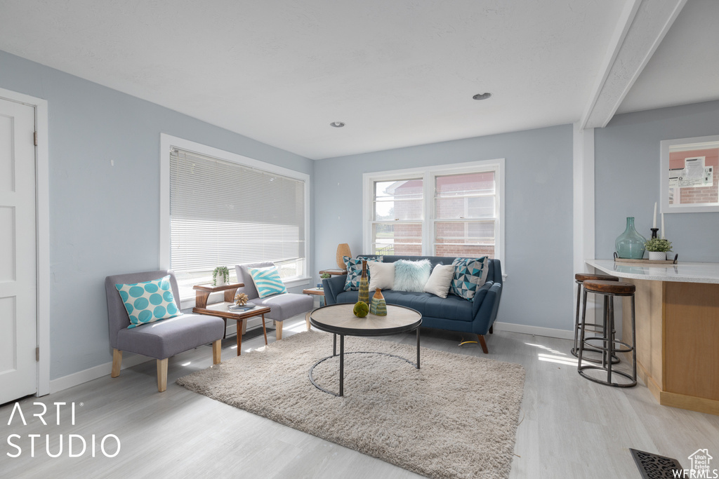 Living area featuring light wood-type flooring, baseboards, and recessed lighting