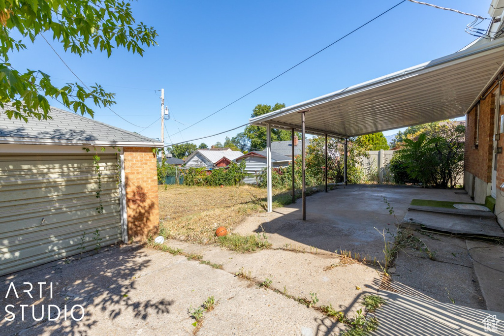 View of patio featuring an outbuilding, a carport, and driveway