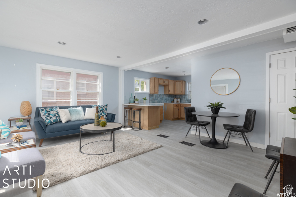 Living room featuring light wood-style flooring, recessed lighting, and baseboards