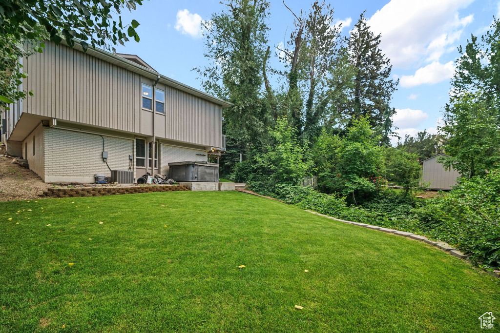 View of green lawn with an attached garage