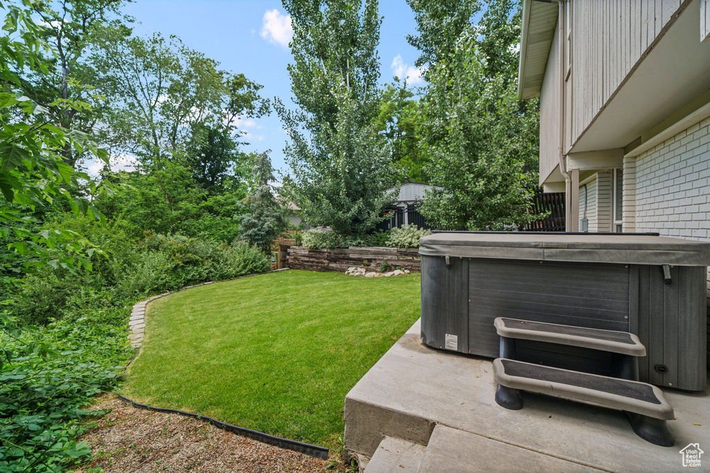 View of yard with a hot tub and a patio