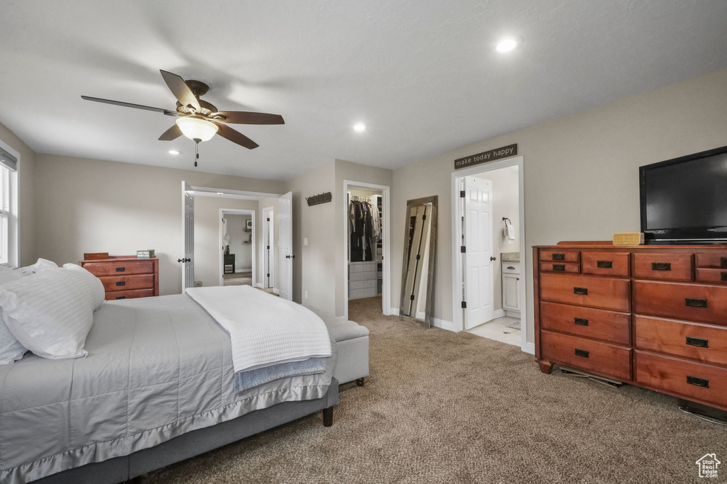Carpeted bedroom featuring a spacious closet, recessed lighting, a closet, ensuite bathroom, and a ceiling fan