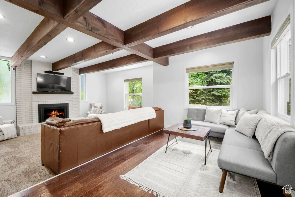 Living area with beam ceiling, recessed lighting, a fireplace, and hardwood / wood-style flooring