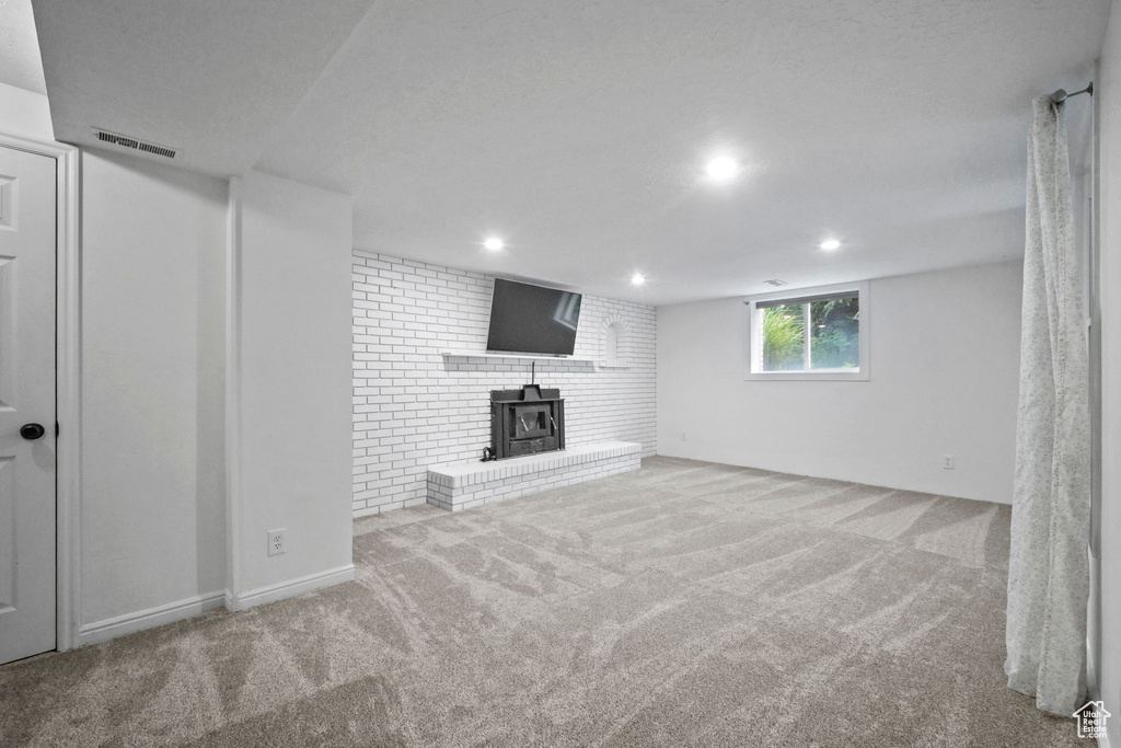 Basement featuring a wood stove, carpet, and recessed lighting