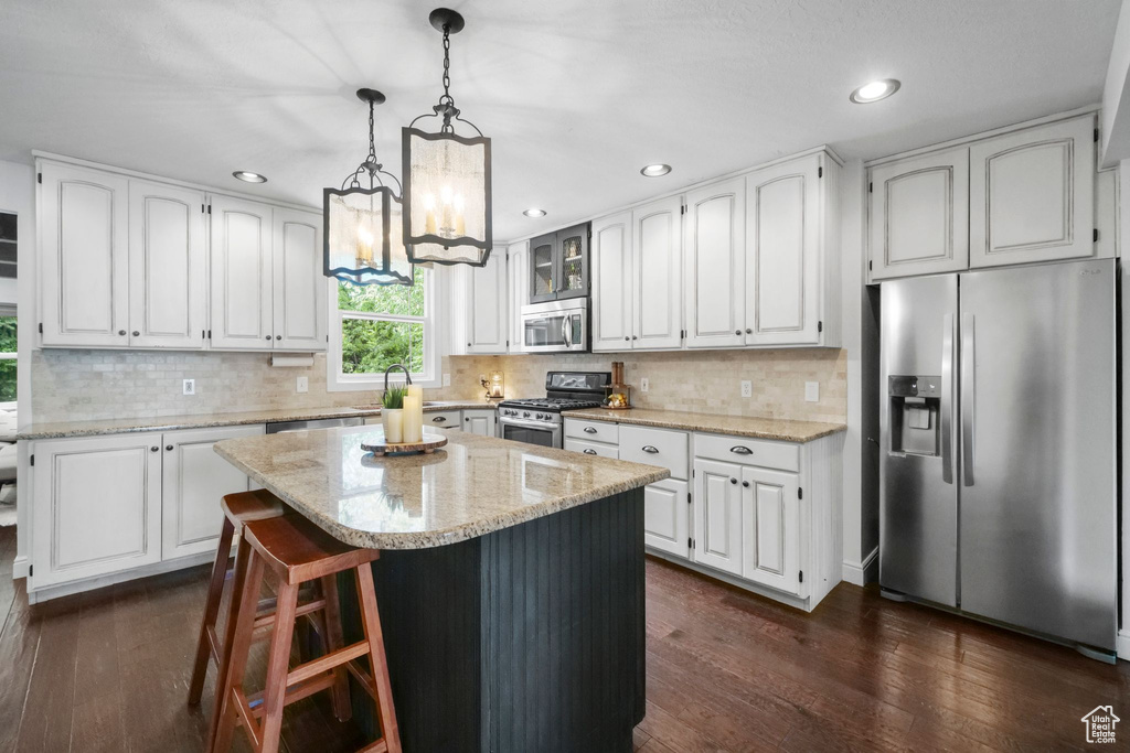 Kitchen featuring stainless steel appliances, dark wood-type flooring, white cabinets, and recessed lighting