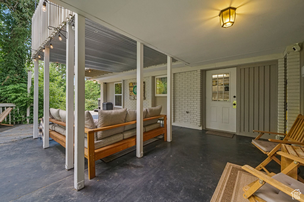 Entrance to property featuring an outdoor hangout area, brick siding, and a patio area