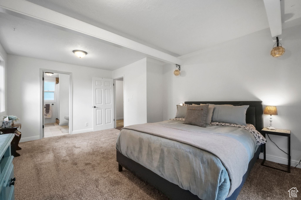 Bedroom with carpet, ensuite bath, and beamed ceiling