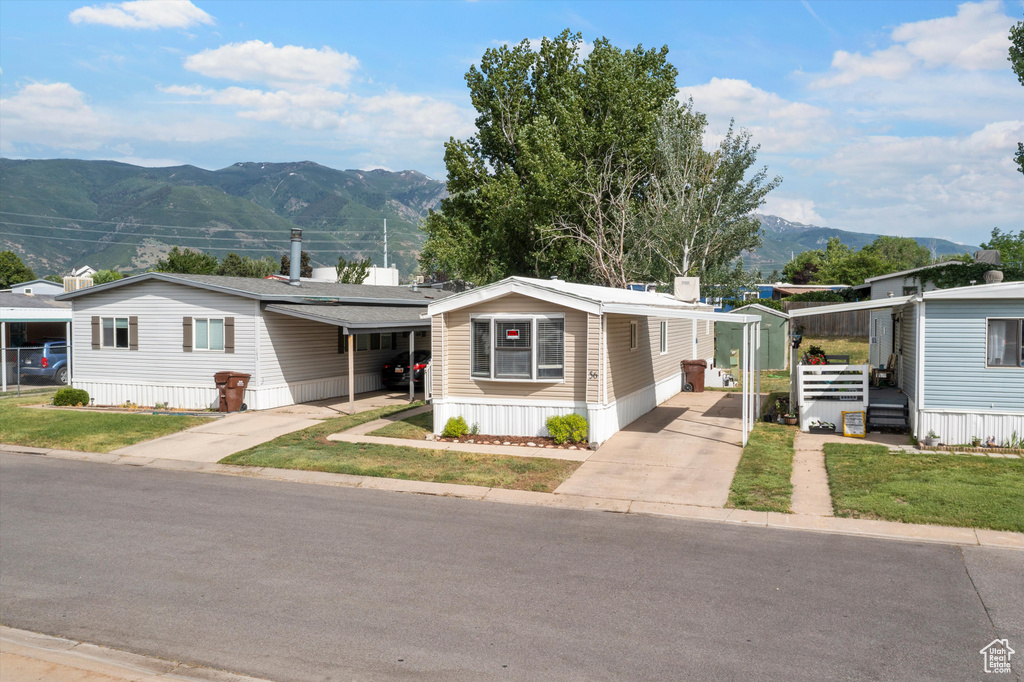 Manufactured / mobile home with driveway, a carport, and a mountain view