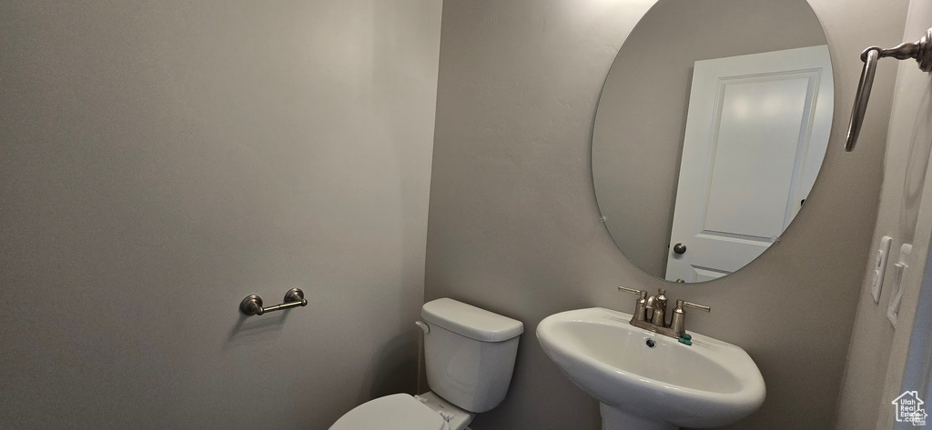 Half bathroom featuring a sink and toilet