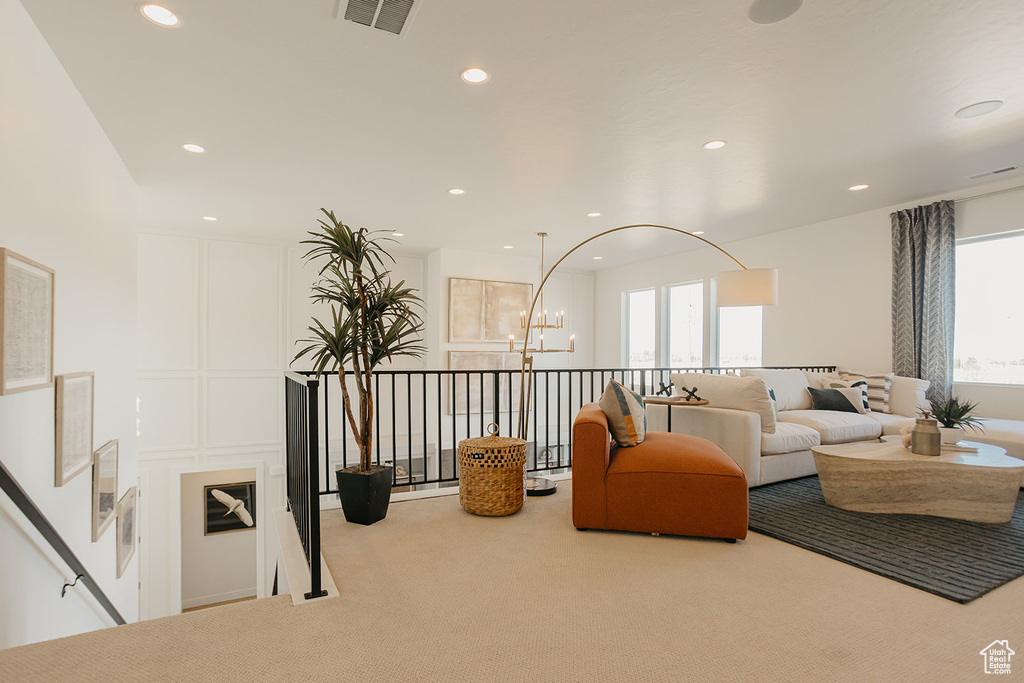 Carpeted living room featuring plenty of natural light, recessed lighting, and a chandelier