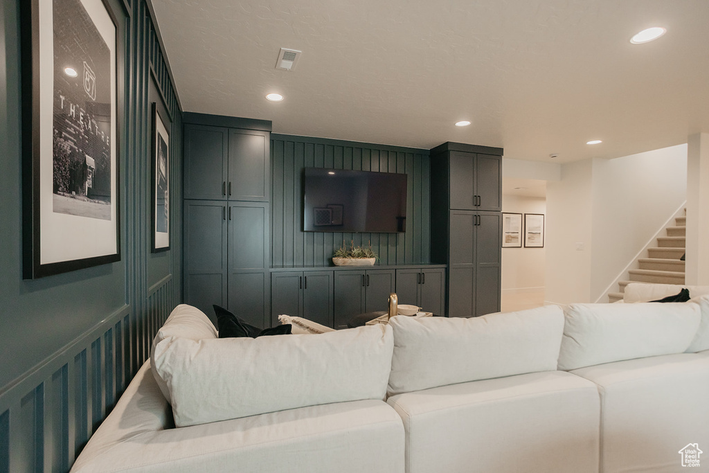 Living area featuring a decorative wall, stairway, and recessed lighting