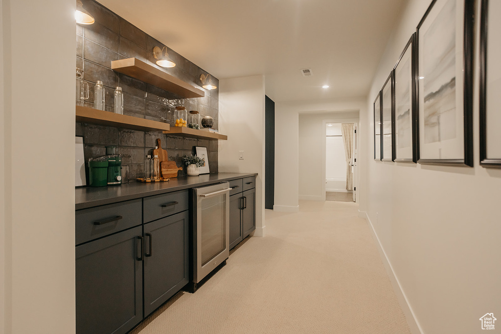 Indoor dry bar with light carpet, beverage cooler, recessed lighting, and backsplash