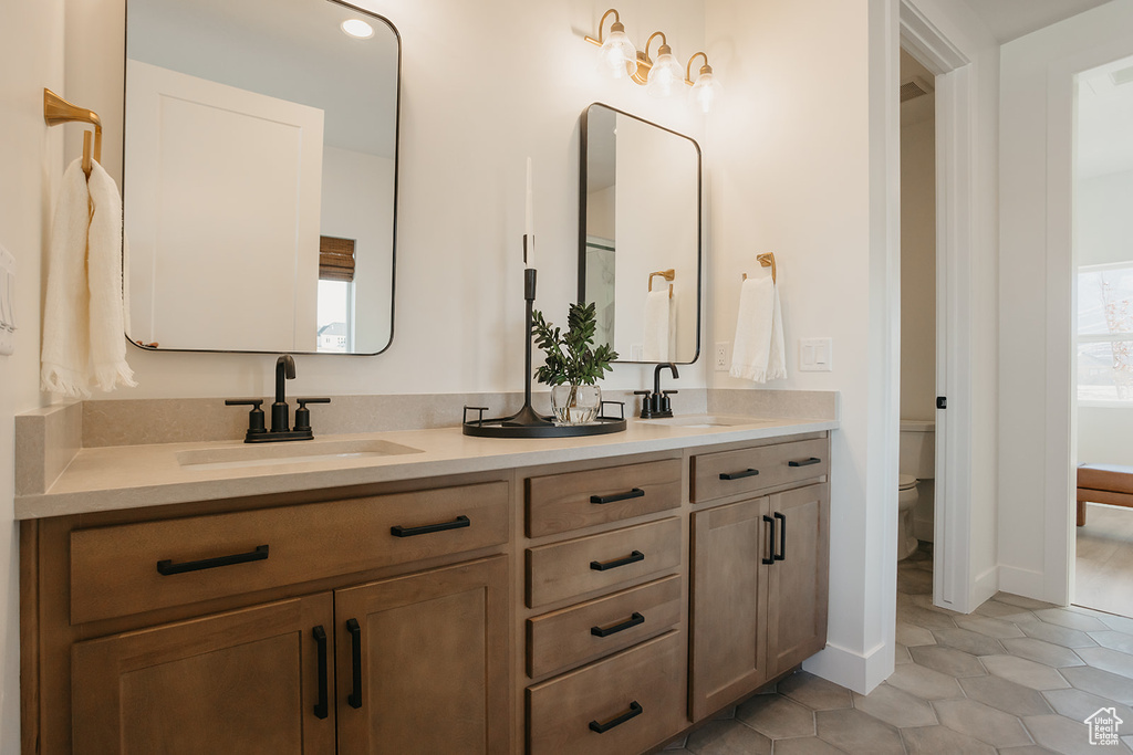 Bathroom with double vanity and tile patterned floors