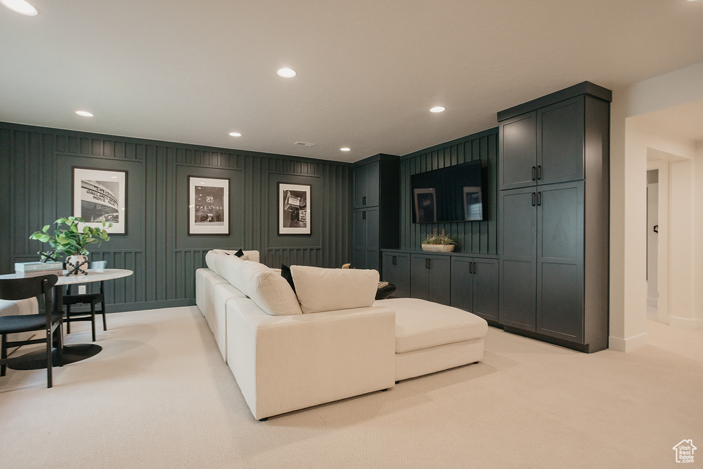 Living room with carpet flooring, recessed lighting, and a decorative wall