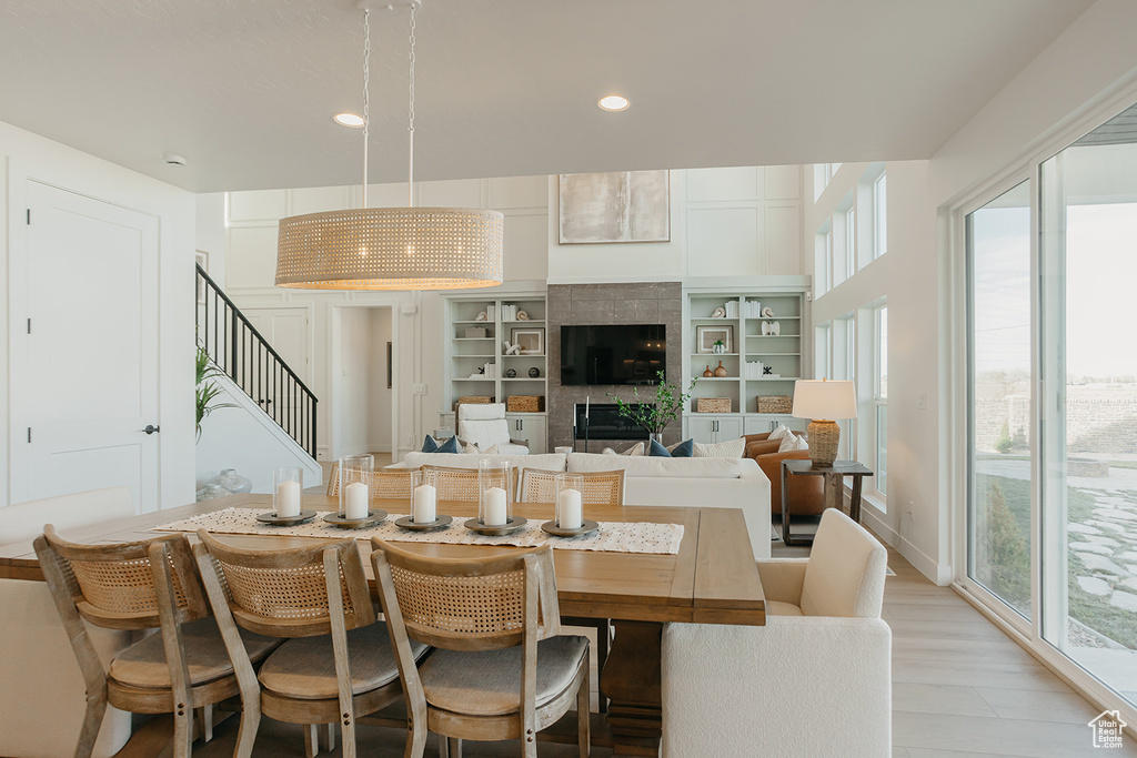 Dining room featuring recessed lighting, stairway, a tile fireplace, and light wood finished floors