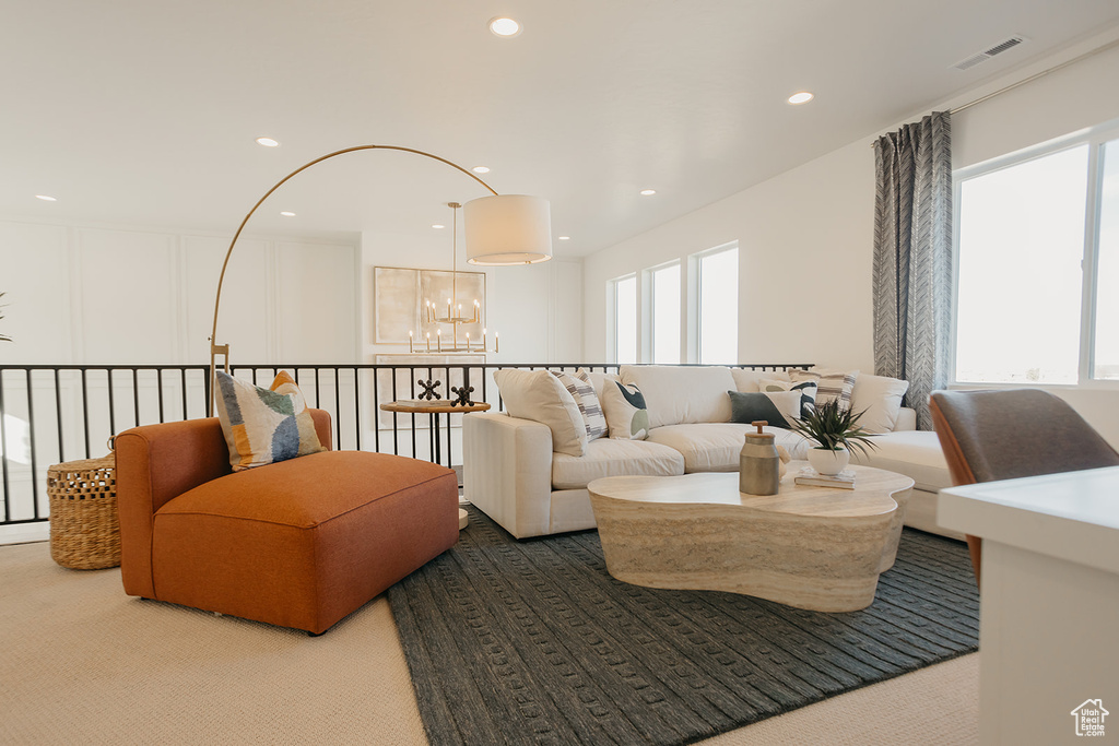 Carpeted living room with a chandelier and recessed lighting