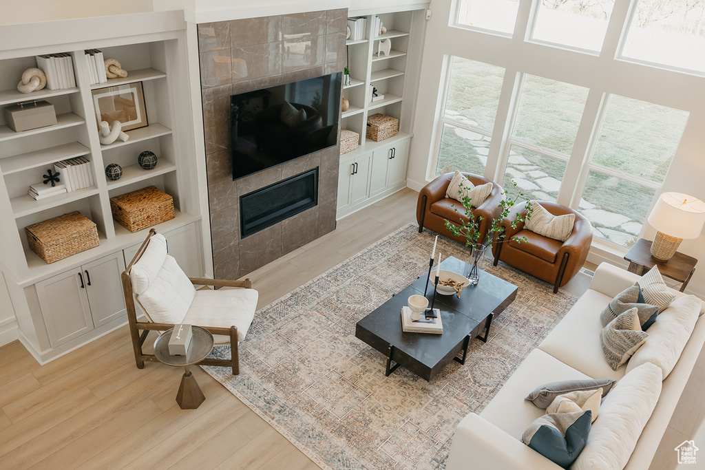 Living area featuring a fireplace, light wood finished floors, and built in shelves