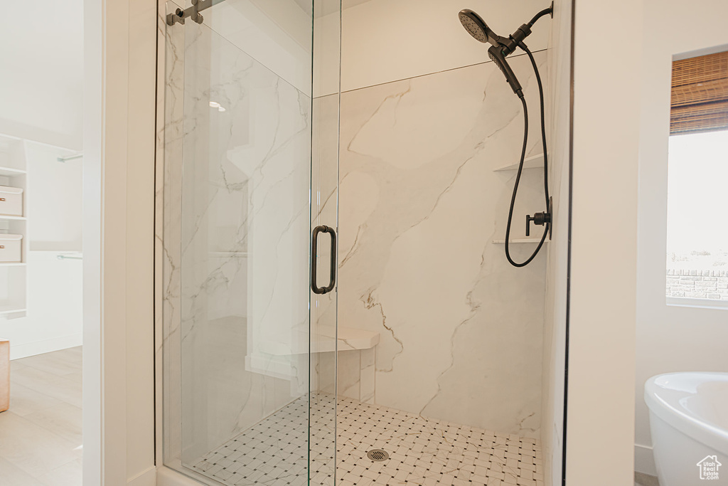 Full bath with a marble finish shower