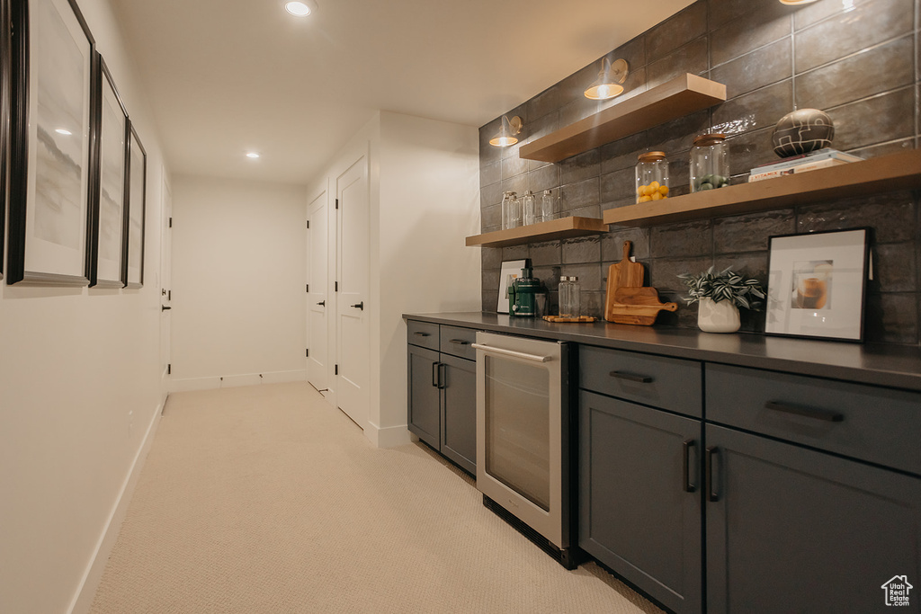 Indoor dry bar featuring wine cooler, decorative backsplash, light carpet, and recessed lighting