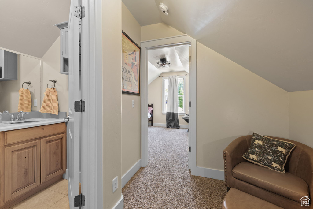 Corridor featuring lofted ceiling and a sink
