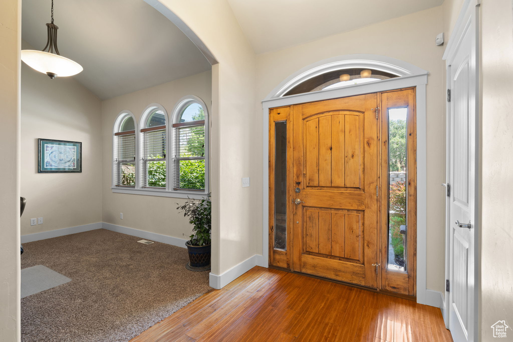 Entryway with arched walkways and hardwood / wood-style flooring