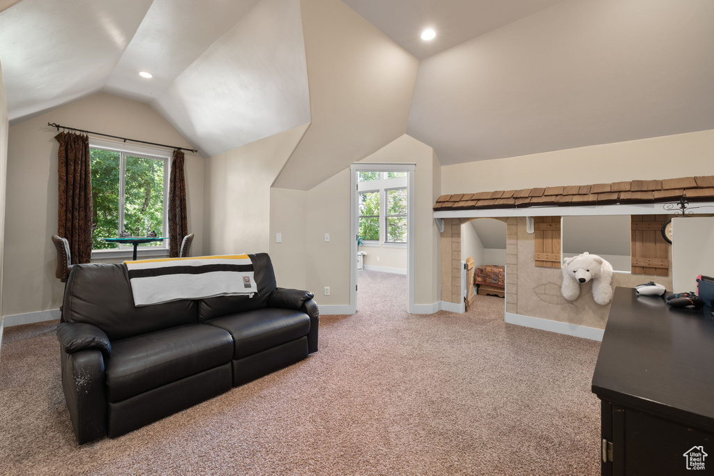 Carpeted living area with vaulted ceiling and recessed lighting