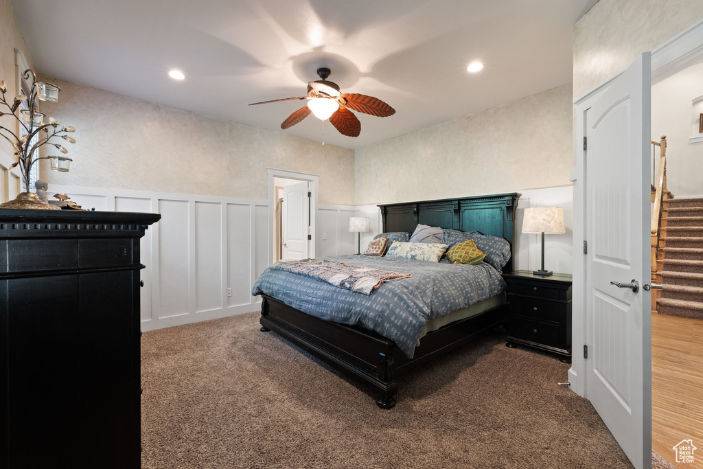 Bedroom with a decorative wall, carpet, a wainscoted wall, ceiling fan, and recessed lighting