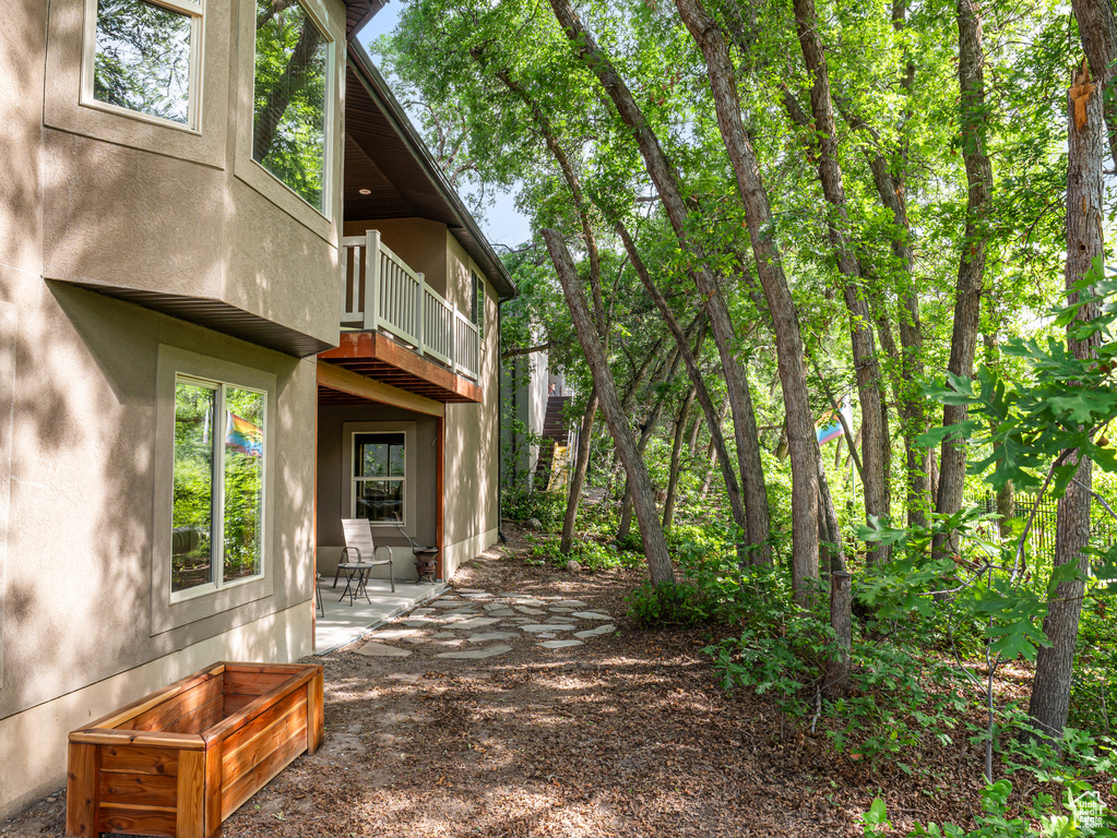 View of yard featuring a balcony and a patio area