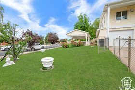 View of yard featuring a garage, a carport, a gazebo, and concrete driveway