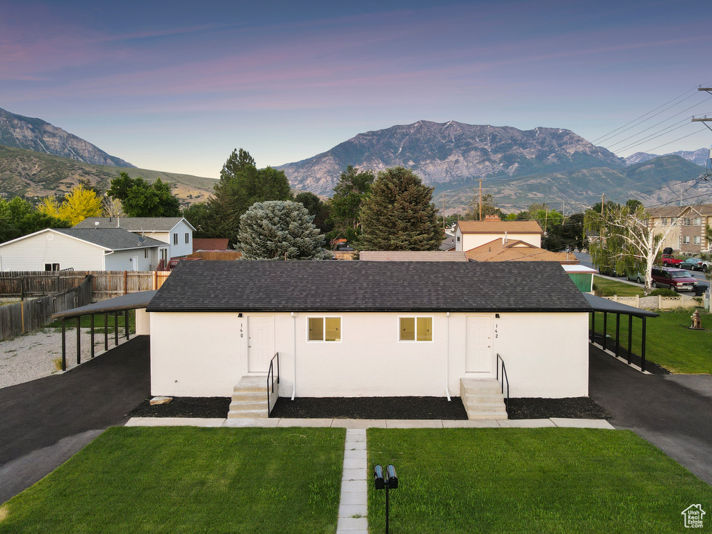 Ranch-style home with entry steps, a mountain view, a carport, and asphalt driveway
