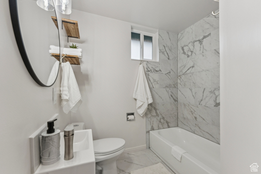 Bathroom with marble finish flooring and shower / bathtub combination