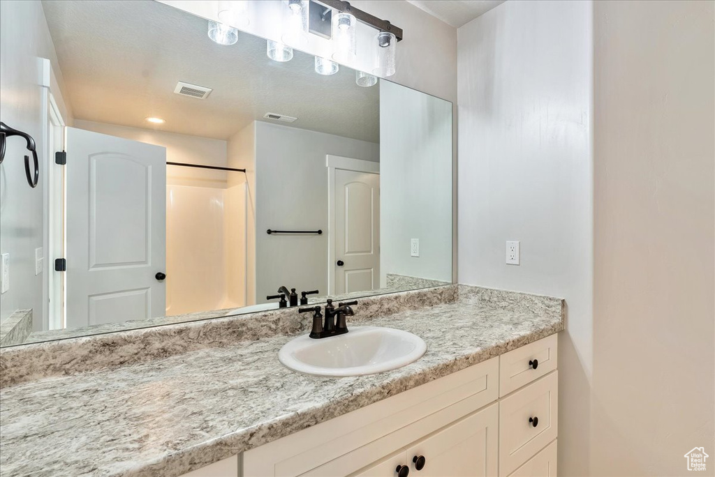 Bathroom featuring vanity and a shower