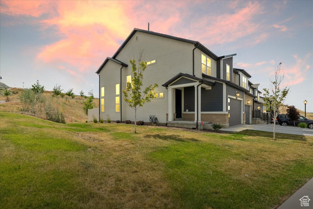 View of front of home with a garage, driveway, and a front yard