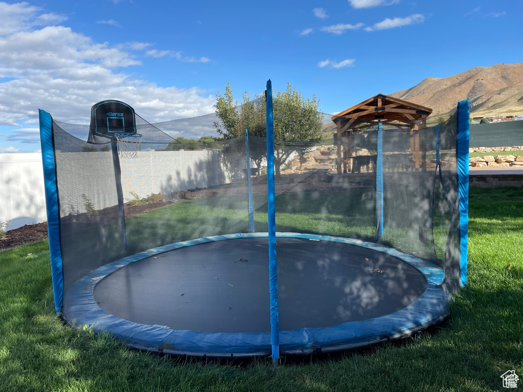 View of yard featuring a trampoline and a mountain view