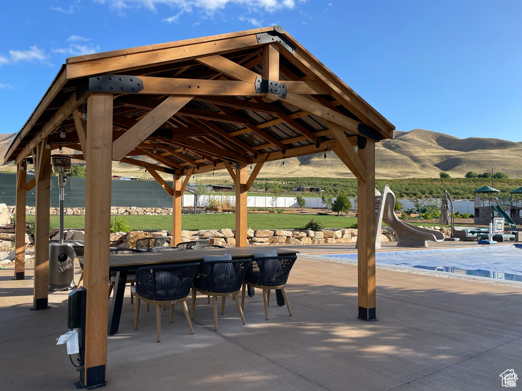 View of property\\\'s community with a patio, a pool, a water and mountain view, and outdoor dining space