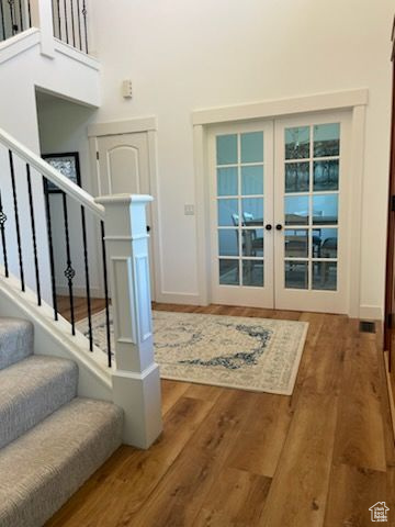 Doorway to outside featuring wood finished floors, stairs, and french doors