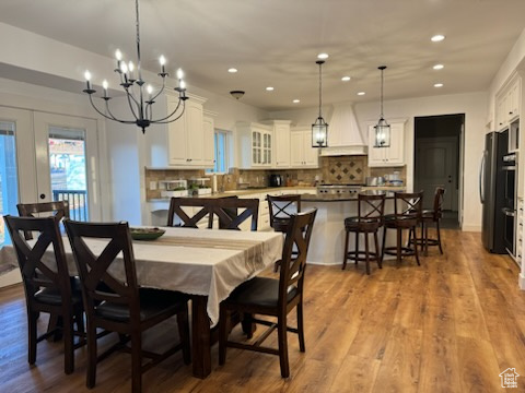 Dining space with recessed lighting, a chandelier, french doors, and wood finished floors