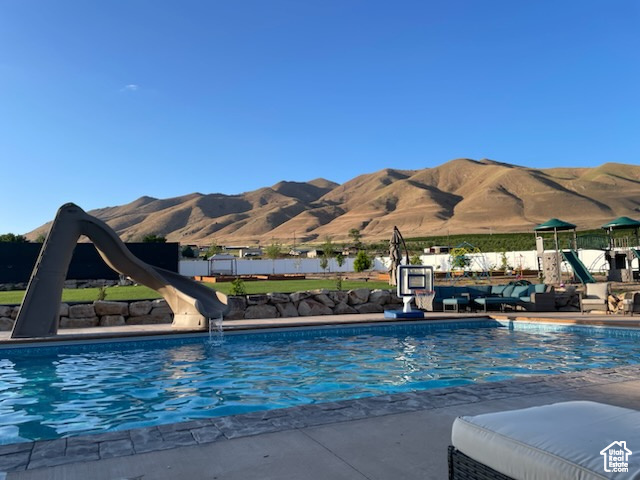 Community pool with a water slide and a mountain view