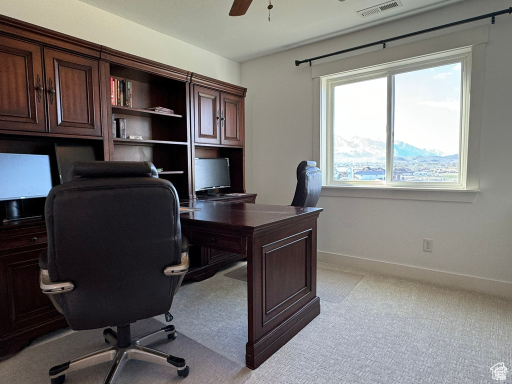 Home office with ceiling fan and light colored carpet